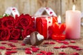 Chocolate pralines in front of bouquet of red roses Royalty Free Stock Photo